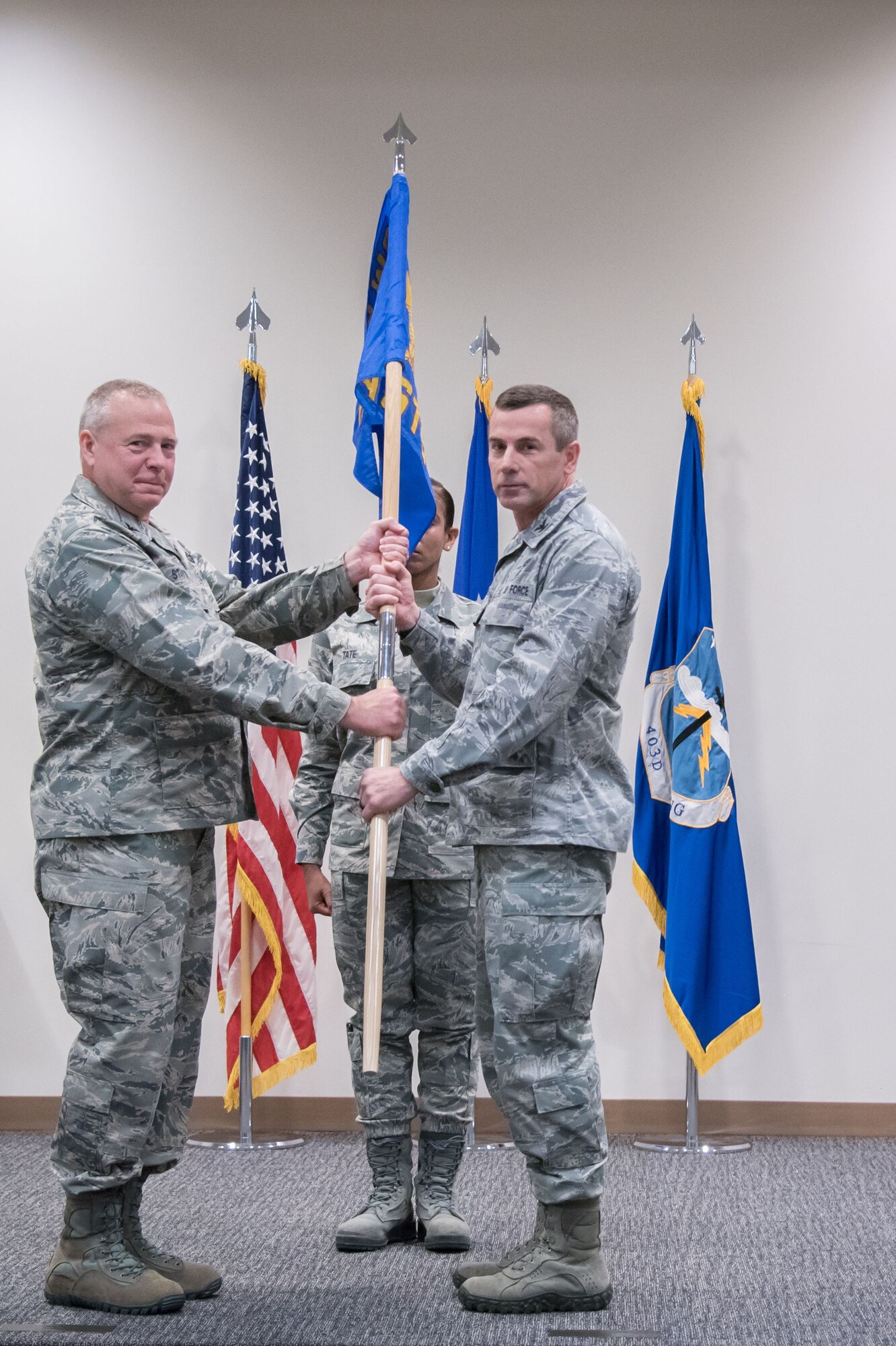 Col. Robert Stanton, 403rd Wing vice commander, passes the 403rd Aeromedical Staging Squadron guidon to new commander Col. Carl Spear, while Master Sgt. Deblair Tate, 403rd ASTS first sergeant, watches during an assumption of command ceremony for the 403rd ASTS Feb. 4, 2017 at Keesler Air Force Base, Mississippi. U.S. Air Force photo by Staff Sgt. Heather Heiney)