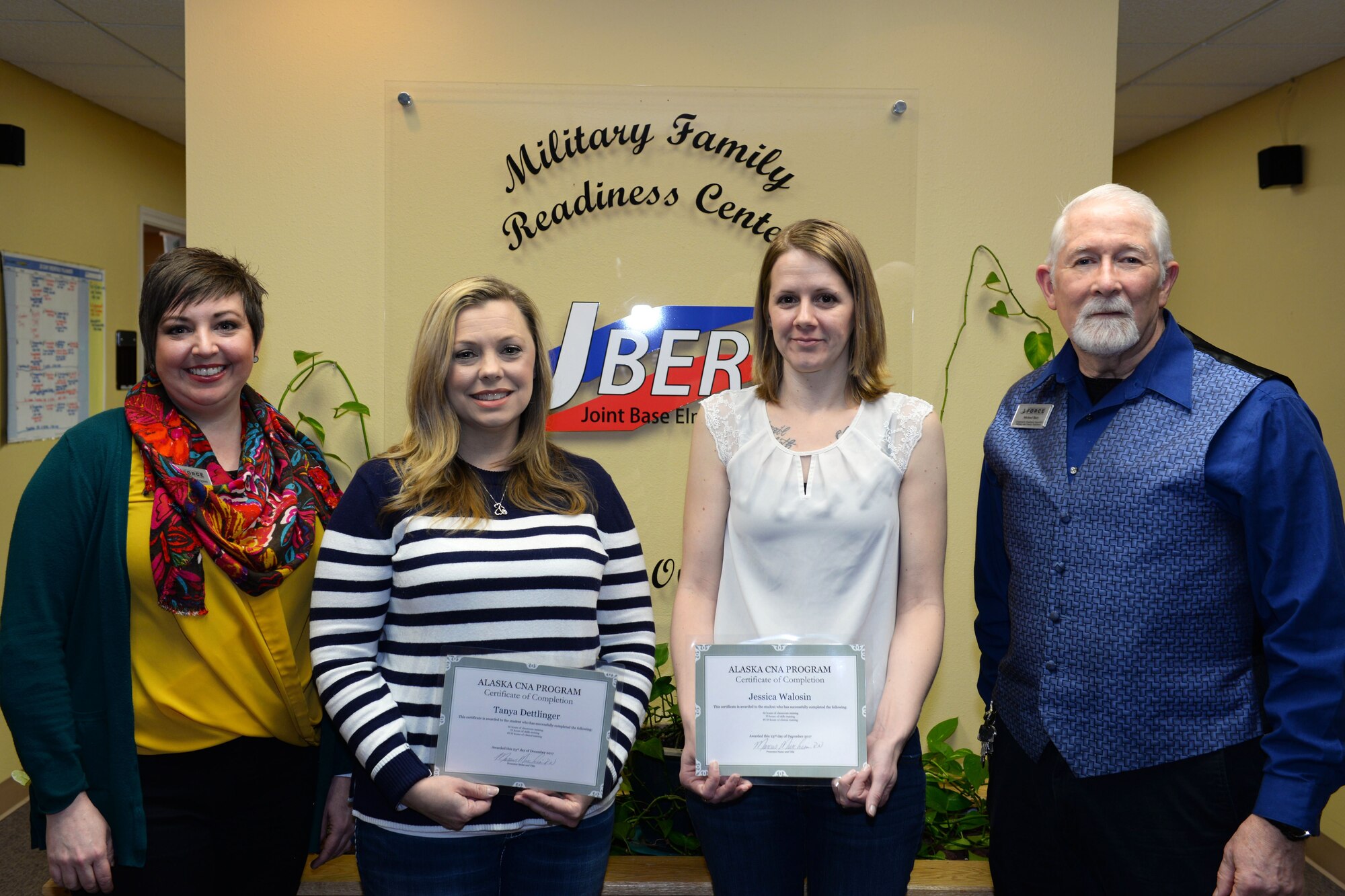 Christie Rodriguez, employment readiness program manager and Michael Baty, a community readiness specialist from the Military & Family Readiness Center, stand with Air Force Aid Society Spouse Employment Program scholarship recipients, Tanya Dettlinger and Jessica Walosin, at Joint Base Elmendorf-Richardson, Alaska, Jan. 30, 2018. The MFRC at JBER annually searches and applies for scholarships and grants to provide military spouses with new employment opportunities.