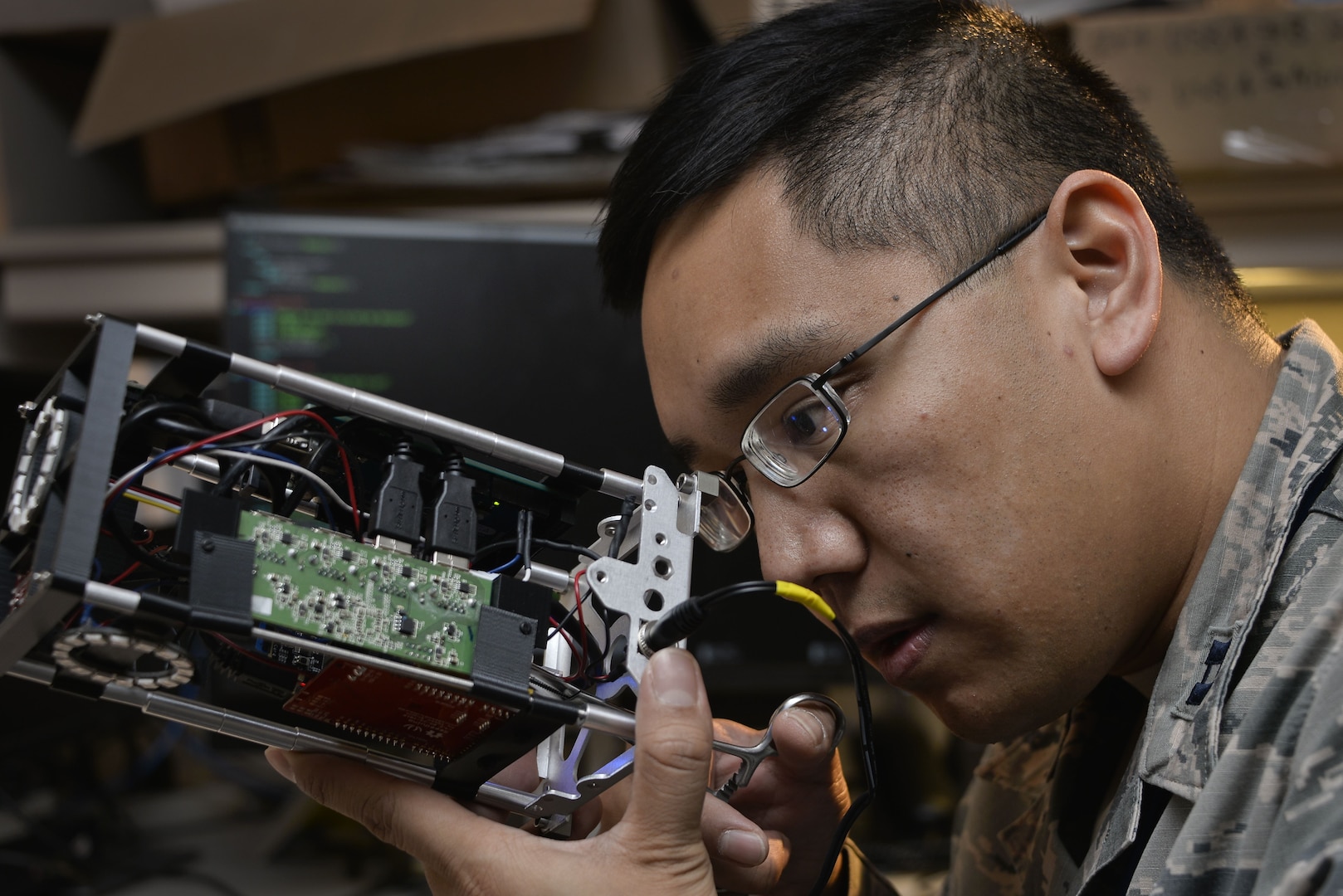 Airman with 707th Communications Squadron Special Missions Flight repairs connection on CubeSat, in Laurel, Maryland, January 2018 (U.S. Air Force/Alexandre Montes)