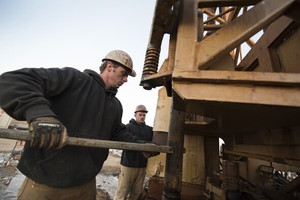 SSgt Zachary Gosteli, a vehicle mechanic assigned to the 557th Expeditionary RED HORSE Squadron, applies torque to steel piping on a well drilling site January 31, 2018 at an undisclosed location in Southwest Asia. The 1500 ft. well began with a hole six inches in diameter, and was soon increased to a 10-inch diameter before the eventual addition of filter screens, reinforcement, and pumps. (U.S. Air Force photo by Staff Sgt. Joshua Kleinholz)