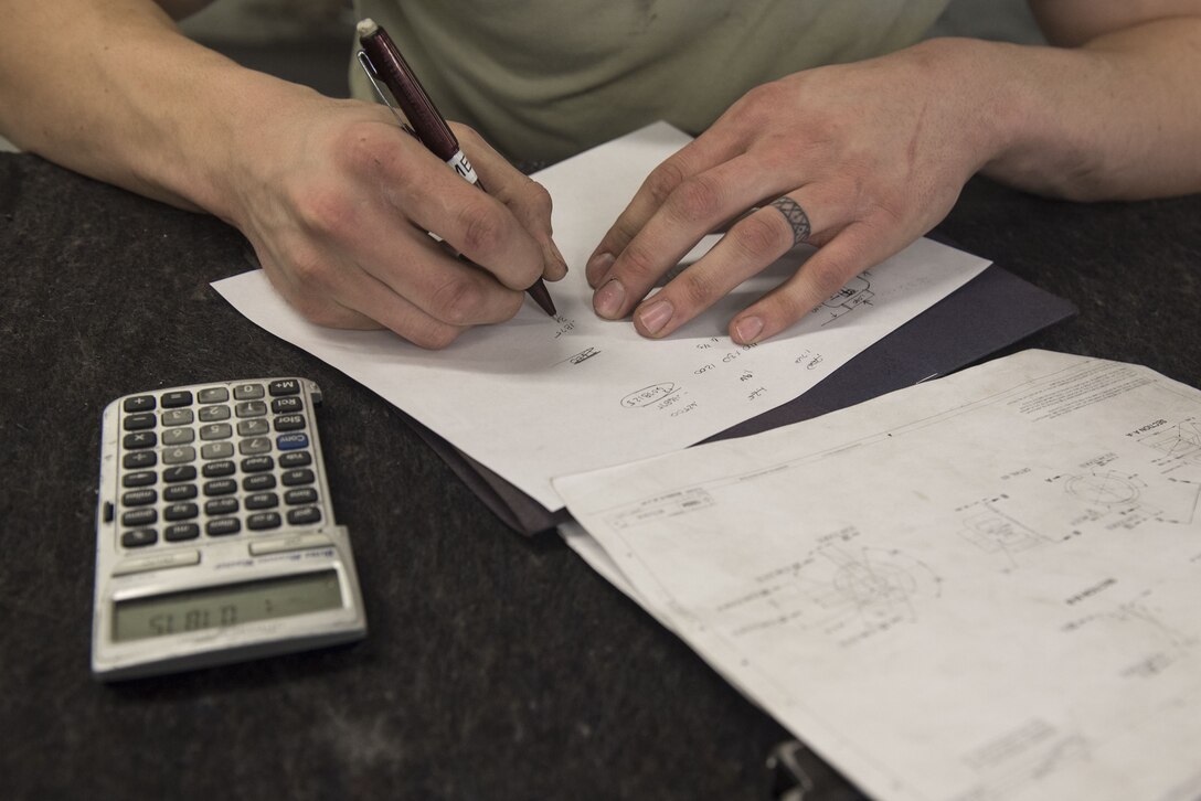 U.S. Air Force Airman 1st Class Walker James, 20th Equipment Maintenance Squadron (EMS) metals technology technician, uses a blueprint to calculate measurements at Shaw Air Force Base, S.C., Jan. 30, 2018.