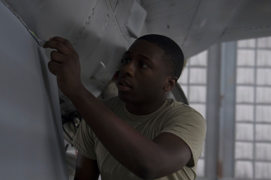 U.S. Air Force Airman 1st Class Kayne Brown, 20th Equipment Maintenance Squadron (EMS) corrosion apprentice, peels masking tape from an F-16CM Fighting Falcon at Shaw Air Force Base, S.C., Feb. 1, 2018.