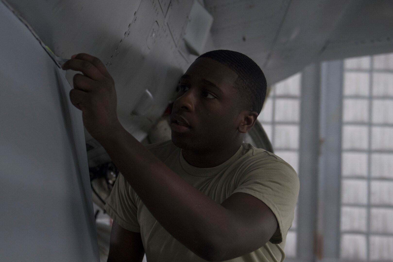 U.S. Air Force Airman 1st Class Kayne Brown, 20th Equipment Maintenance Squadron (EMS) corrosion apprentice, peels masking tape from an F-16CM Fighting Falcon at Shaw Air Force Base, S.C., Feb. 1, 2018.
