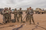 A platoon leader with 1st Battalion, 158th Infantry Regiment gives an air assault mission brief to his Soldiers before moving to the flight line for takeoff.