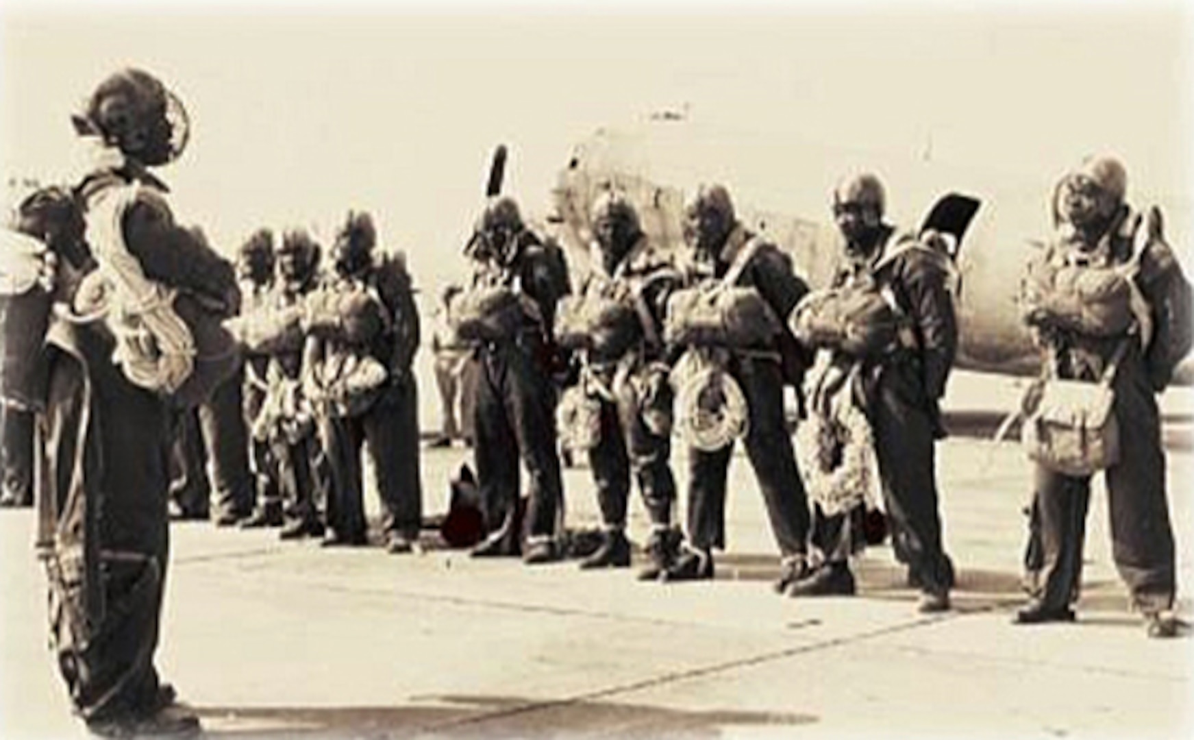 Paratroopers of the U.S. Army's 555th Parachute Infantry Battalion stand at ease during inspection. The men were issued "let-down" ropes and football helmets with face masks to assist during forest landings while detailed to the U.S. Forest Service, where they served as "smokejumpers" at the end of World War II.