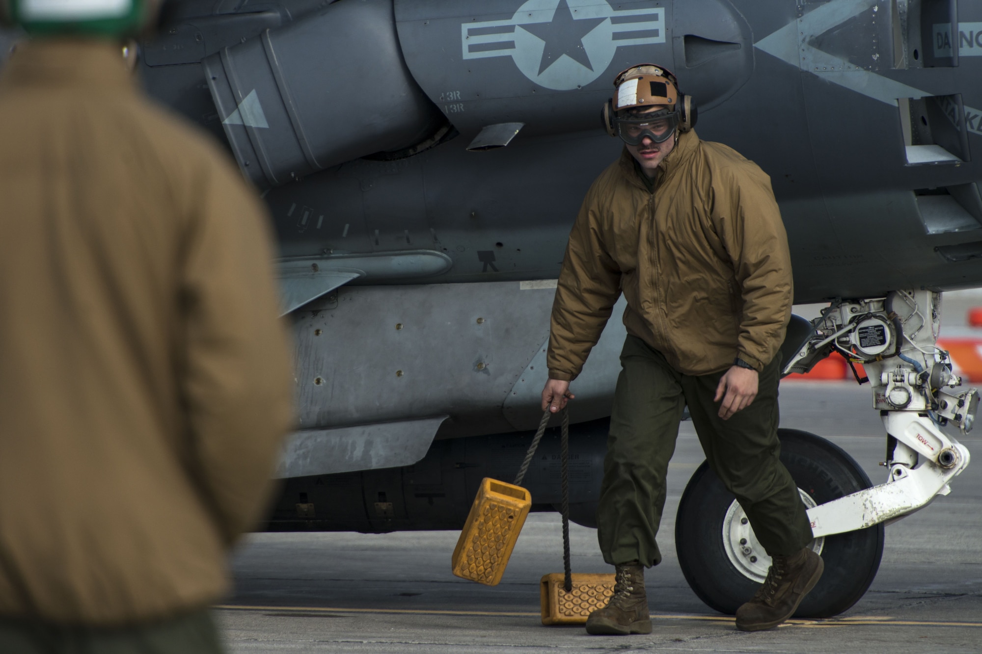 Sgt. Brandon Erway Marine Attack Squadron 542 powerline plane captain, removes the wheel chocks from underneath the AV-8B Harrier II Jan. 31, 2018, at Mountain Home Air Force Base, Idaho. Working in cold weather conditions and side-by-side with the Air Force will help VMA-542 train for its mission. (U.S. Air Force Photo by Airman 1st Class JaNae Capuno)