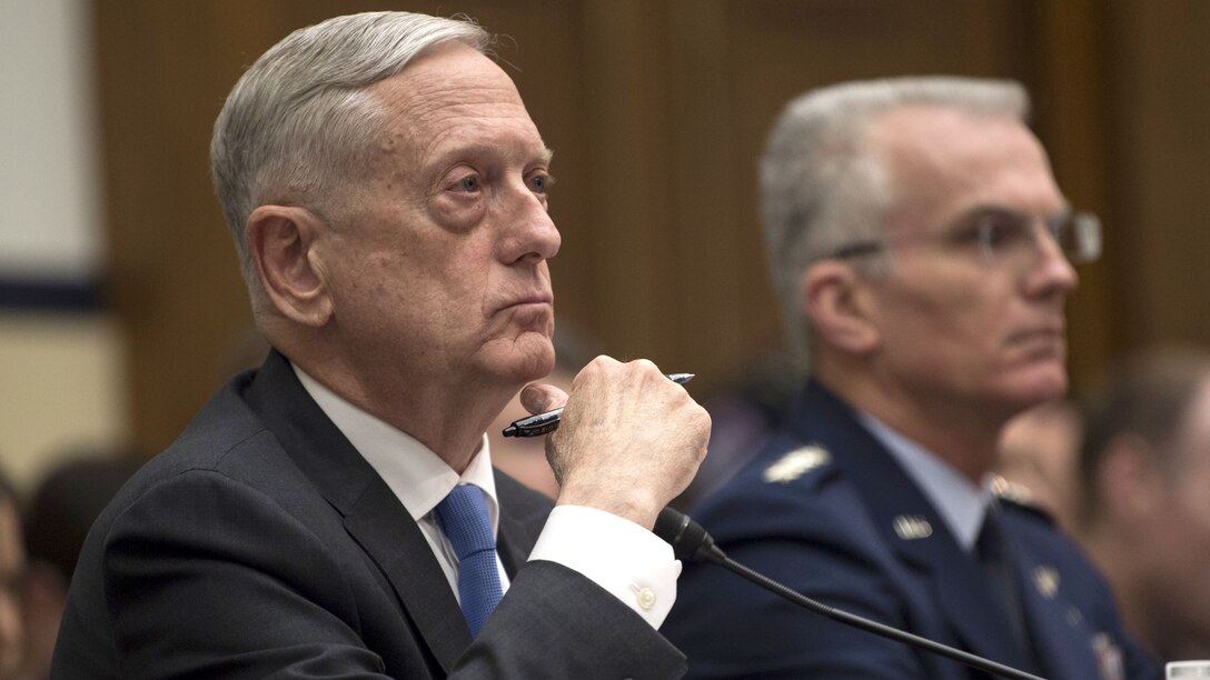 Defense Secretary James N. Mattis and the vice chairman of the Joint Chiefs of Staff sit behind a desk.