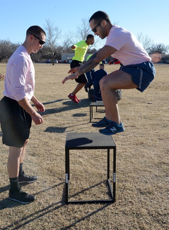 From left, Senior Airman Seth Mannos, 72nd Operations Support Squadron, and Senior Airman Caleb Snovel, 138th Maintenance Squadron, alternate jumping onto a stand during PT at Airman Leadership School Jan. 23.