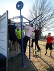 Tech. Sgt. Ricky Dent, right, an instructor at Airman Leadership School, oversees members of the current class as they perform pull-ups on the stations attached to the outside of the new Combat Cube.