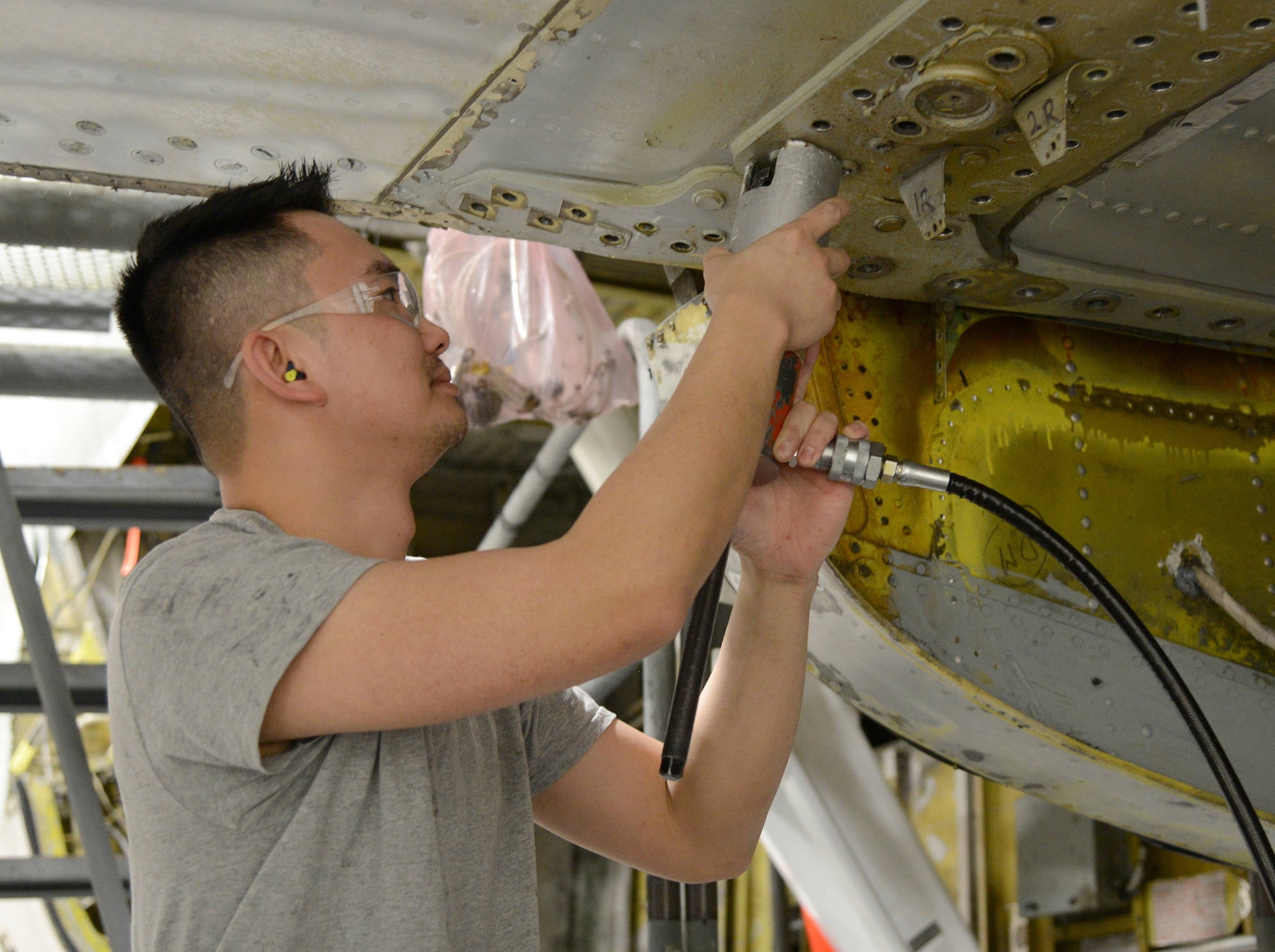 Jet Le, a sheetmetal mechanic with the 545th Aircraft Maintenance Squadron, pulls out a bolt on the boomerang section of the terminal of a KC-135 Stratotanker. Mr. Le has worked at Tinker for two years after completing the Pathway intern program through Francis Tuttle Technology Center.