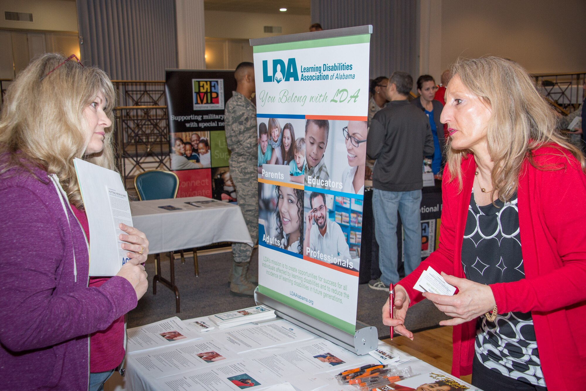Tamara Massey with the Learning Disabilities Association of Alabama organization talks with a guest at the Exceptional Family Member Program Town Hall and Information Fair, Jan. 31, 2018, at the Maxwell Club. The event drew more than 100 people and 25 on- and off-base EFMP service providers. The town hall was held to share information with EFMP families, friends and coworkers about available services and about the program itself. (U.S. Air Force photo by William Birchfield)