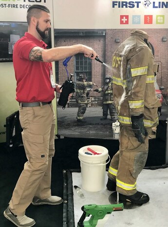 IMAGE: CHANTILLY, Va. – A First Line Technology employee demonstrates application of the Dahlgren Decontamination solution, known as Dahlgren Decon, for decontaminating a fire suit. The Federal Laboratory Consortium for Technology Transfer (FLC) selected Dahlgren Decon technology for a 2018 Excellence in Technology Transfer Award, Naval Surface Warfare Center Dahlgren Division (NSWCDD) announced, Feb. 2. Dahlgren Decon was invented and developed by NSWCDD to defend warfighters against chemical, biological, and radiological agents. In September 2016, the command signed an exclusive license agreement with First Line Technology, a Virginia-based small business, permitting it to manufacture the life-saving decontamination technology for warfighters and first responders nationwide.