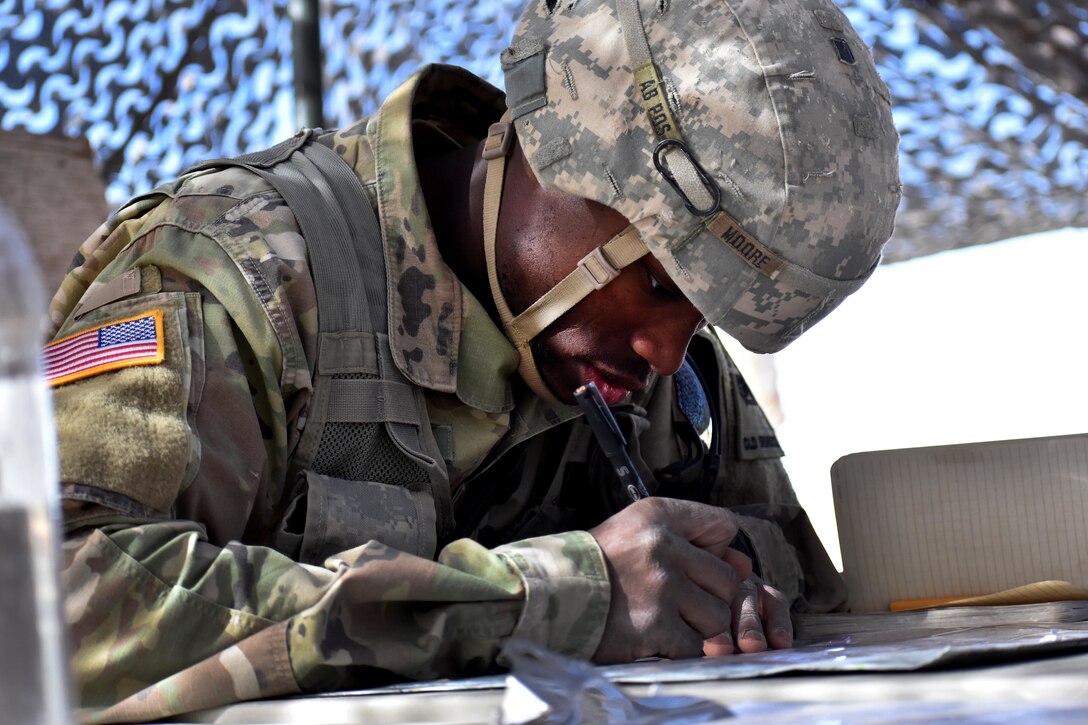 A soldier writes down grid coordinates.