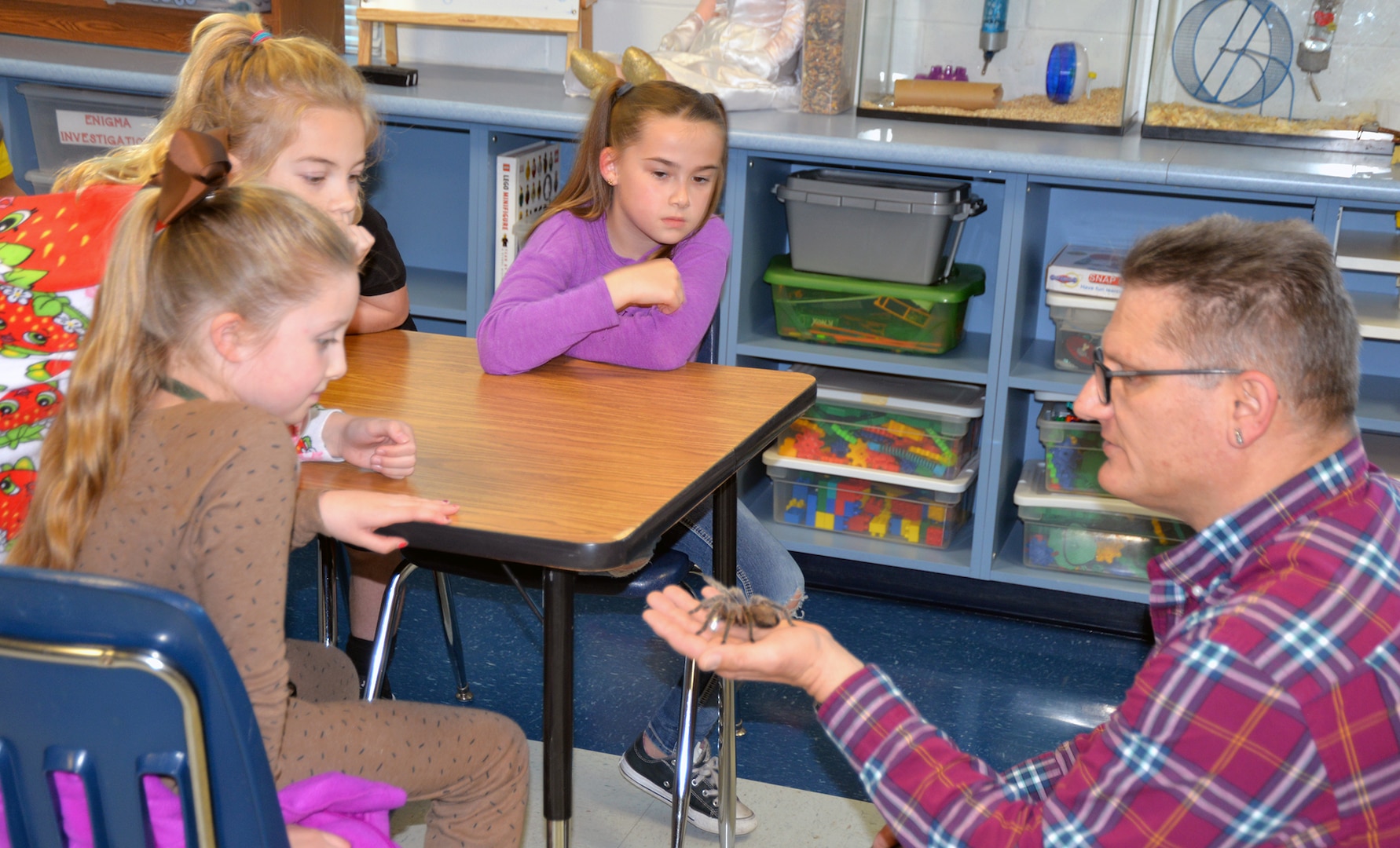 Second-grade students at Fort Sam Houston Elementary School observe a tarantula being handled by Dr. William Miller, U.S. Army Environmental Command entomologist, Jan. 31. Miller came to the gifted and talented program class of Laura Lamoureux to talk to the children about insects and arachnids, including their characteristics and how they can grow from an immature form to an adult.