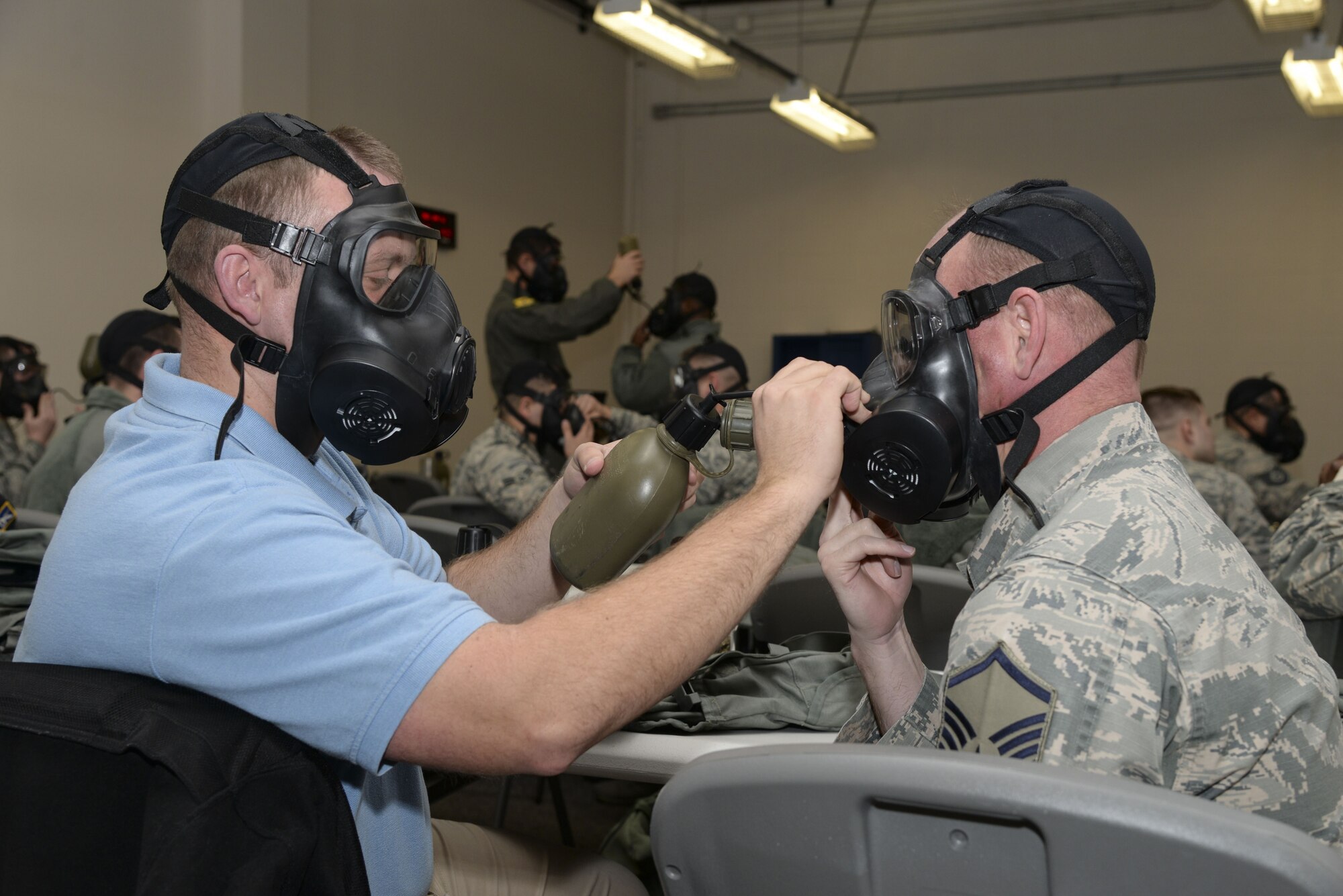 Investigator Michael Lawrence, 436th Security Forces Squadron NCO in charge of investigations and intelligence, and Master Sgt. Anthony Kinnick, 436th SFS chief of standards and evaluations, practice gas mask hydration during a Chemical, Biological, Radiological and Nuclear (CBRN) training session Jan. 31, 2018, at Dover Air Force Base, Del. During a CBRN event, Mission Oriented Protective Posture, or MOPP gear, cannot be removed, so drinking is accomplished through a special port on the gas mask. (U.S. Air Force photo by Staff Sgt. Aaron J. Jenne)