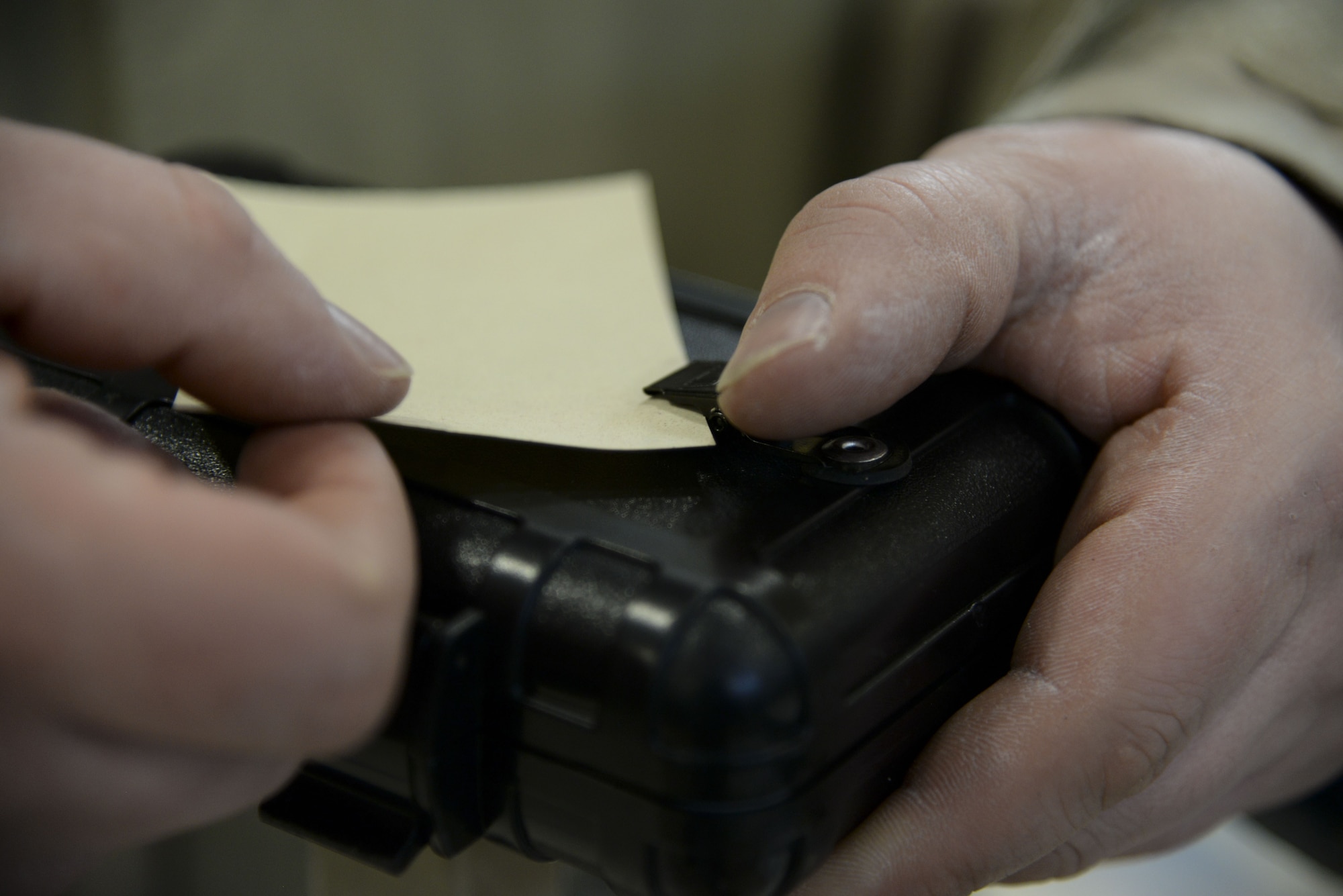 An Airman affixes M8 chemical detection paper to a stanchion during a Chemical, Biological, Radiological and Nuclear (CBRN) training session Jan. 31, 2018, at Dover Air Force Base, Del. M8 paper is used to detect the presence of nerve and blister chemical agents. (U.S. Air Force photo by Staff Sgt. Aaron J. Jenne)