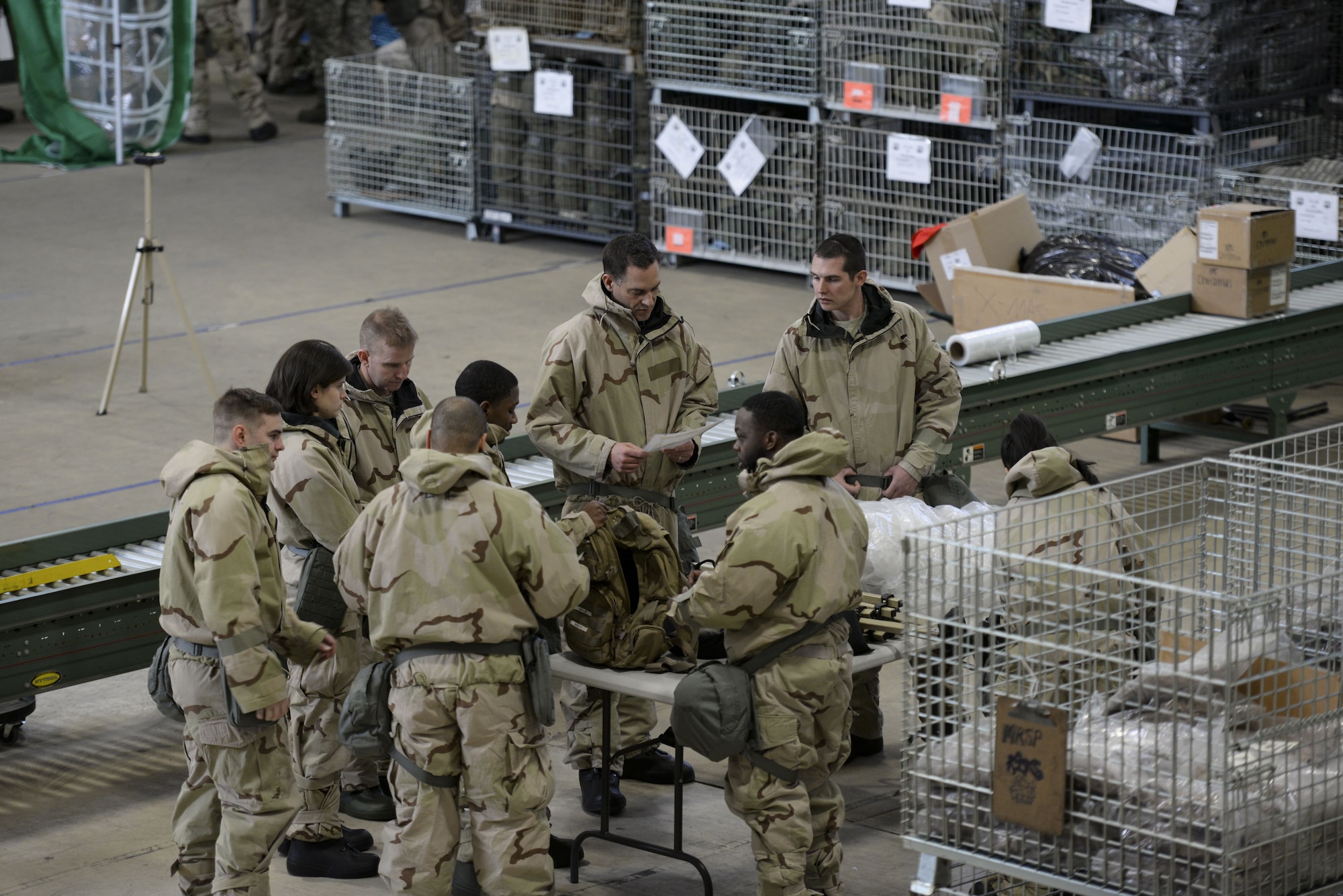 Col. Ethan Griffin, 436th Airlift Wing commander, (back middle) directs a team of Airmen to prepare for a simulated chemical attack during a Chemical, Biological, Radiological and Nuclear (CBRN) training session Jan. 31, 2018, at Dover Air Force Base, Del. Prior to a chemical attack, all assets need to be covered in a protective layer with chemical indicators to reduce the risk of contamination. (U.S. Air Force photo by Staff Sgt. Aaron J. Jenne)