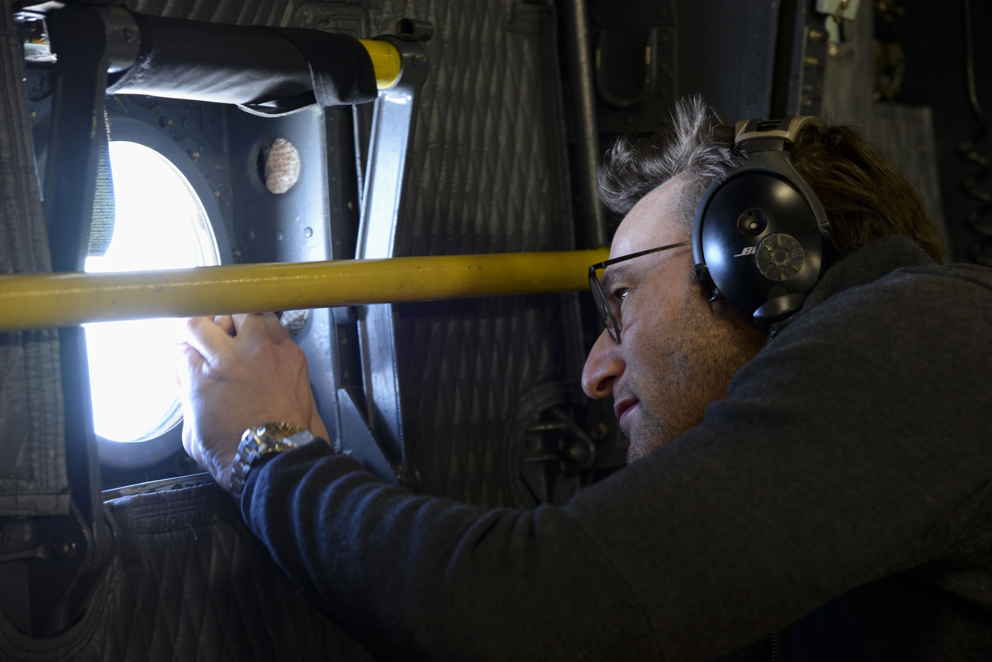 Simon Sinek takes a photo from a window in the cargo compartment of a C-5M Super Galaxy during a training flight Feb. 2, 2018. The three-hour flight took the aircrew over Kentucky where it received fuel from an Ohio Air National Guard KC-135 Stratotanker. (U.S. Air Force photo by Staff Sgt. Aaron J. Jenne)