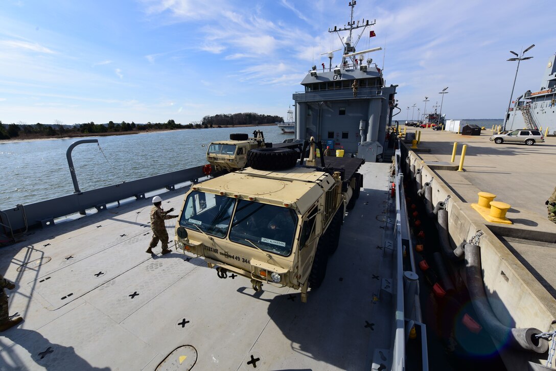 Members of the 149th Seaport Operations Company, 10th Battalion, 7th Transportation Brigade (Expeditionary), load vehicles onto a vessel on Fort Eustis' 3rd Port at Joint Base Langley-Eustis, Va., Feb. 1, 2018. The roll-on, roll-off exercise gave the 149th SOC hands-on training for port operations. (U.S. Air Force photo by Airman 1st Class Monica Roybal)