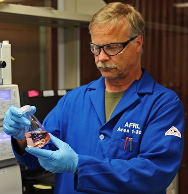 Milton McKay, a now-retired member of the AFRL Aerospace Systems Directorate Propellants Branch handles a sample of AF-M315E, a green alternative to hydrazine. AFRL recently licensed the propellant to Digital Solid State Propulsion for commercialization. (Courtesy photo)
