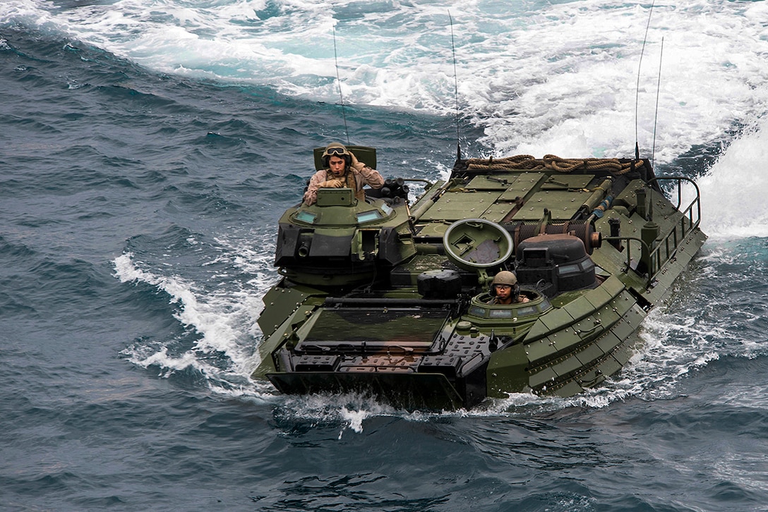 Marines in an amphibious assault vehicle navigate in the water.