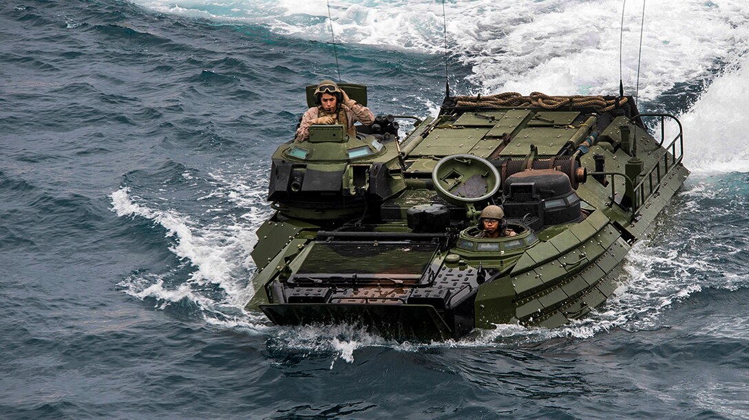 Marines in an amphibious assault vehicle navigate in the water.