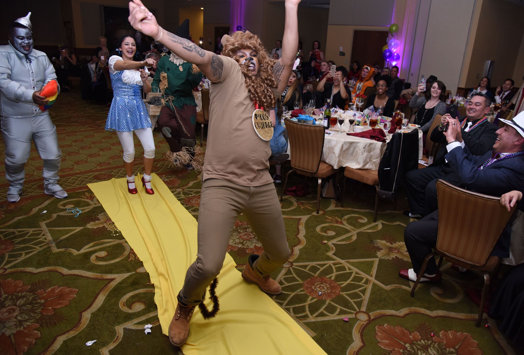 Senior Airman Rashawn Thompson, 81st Medical Operations Squadron mental health technician, dressed as the Cowardly Lion from The Wizard of Oz, dances down the aisle during a Mardi Gras float contest at the 30th Annual Krewe of Medics Mardi Gras Ball at the Bay Breeze Event Center Feb. 3, 2018, on Keesler Air Force Base, Mississippi. The Krewe of Medics hosts a yearly ball to give Keesler Medical Center personnel a taste of the Gulf Coast and an opportunity to experience a traditional Mardi Gras. The theme for this year's ball was Read It-Be It. The 81st MDOS won first place in the float contest. (U.S. Air Force photo by Kemberly Groue)