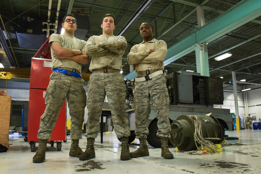 (From left) Airman 1st Class Christopher Palomares, Senior Airman Dustin Holmes, and Staff Sgt. Robert Gordon, 5th Maintenance Squadron aerospace ground equipment technicians, stand near a removed generator at Minot Air Force Base, N.D., Jan. 24, 2018. Aerospace ground equipment technicians are responsible for delivery, maintenance and inspection of equipment used on the flight line. (U.S. Air Force photo by Senior Airman Jessica Weissman)