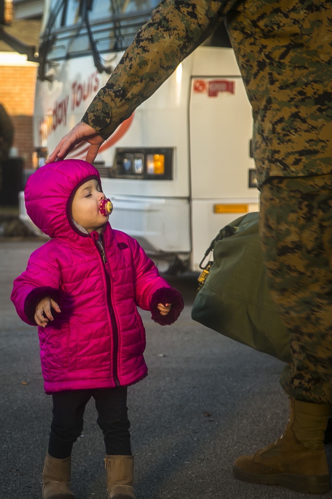 A child interacts with a U.S. Marine with the 26th Marine Expeditionary Unit (MEU), during the unit's departure from Camp Lejeune, N.C., to embark on a deployment at sea Feb. 6, 2018. The MEU Marines and Sailors are deploying to support maritime security operations, crisis response and theater security cooperation, while also providing a forward expeditionary naval presence in Europe and the Middle East.