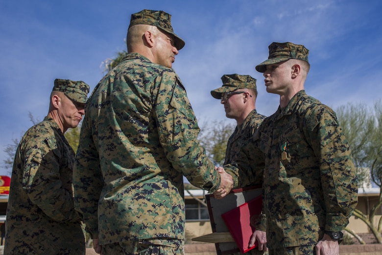 Major General William F. Mullen III, base commanding general, Marine Air Ground Task Force Training Command, Marine Corps Air Ground Combat Center presents Cpl. Branden Nickolas Shaver, Trail Services Clerk, Legal Services Specialist Team, Alpha Company with an award in recognition of his exemplary service aboard MCAGCC, Jan. 16, 2018. The Marines were being awarded the Navy and Marine Corps Achievement Medal for above-and-beyond service both in and out of uniform. (U.S. Marine Corps photo by Pfc. Rachel K. Porter)