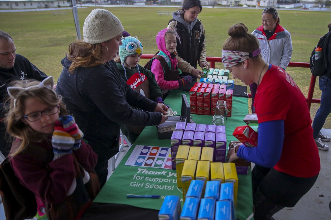 Girl Scouts sell cookies during the Cookie Kick-Off Run Feb. 4 at the parade deck aboard Camp Foster, Okinawa, Japan. Camp Foster Girl Scout Troop 422 hosted the event to promote the beginning of their cookie sale season, giving a box of cookies to each participant who registered for the event. The Girl Scouts have booths set up at the Foster Commissary on the weekends for anyone interested in purchasing cookies or donating to the troop. (U.S Marine photo by Pfc. Nicole Rogge)