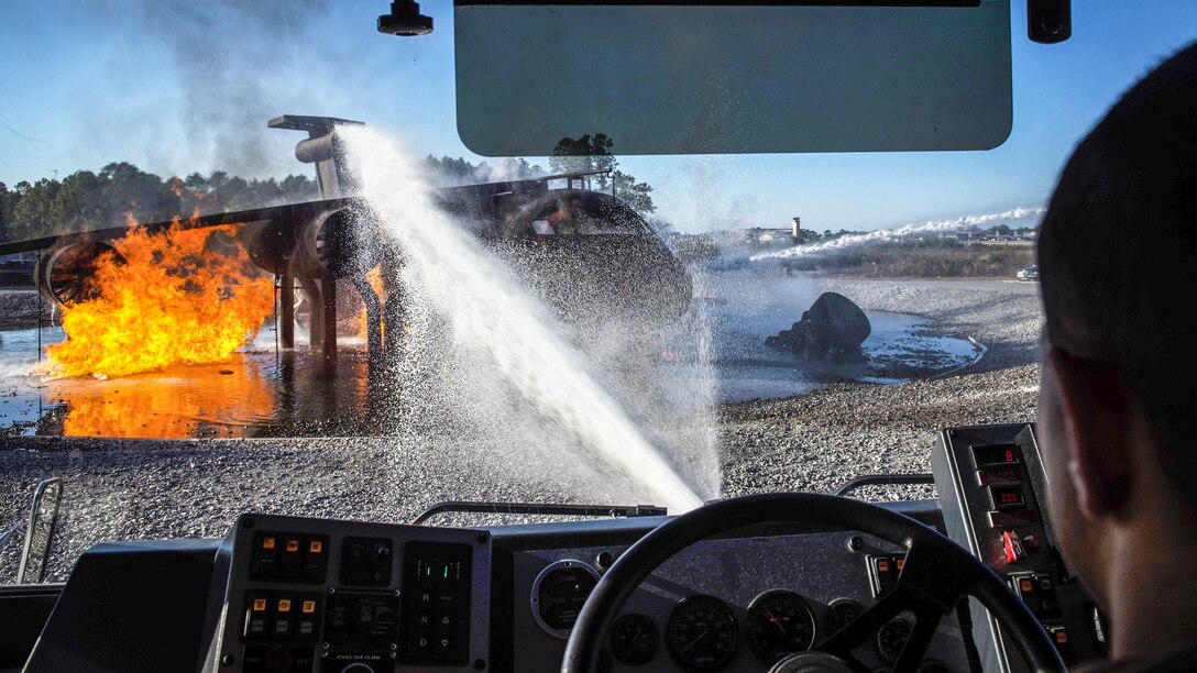 An airman sprays water from a vehicle as he participates in a firefighting exercise.