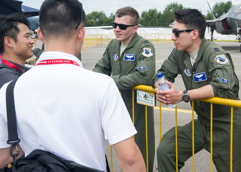(Right) U.S. Air Force Capt. Christopher Richardson and Capt. Jonathan Keranen, 525th Fighter Squadron F-22 Raptor pilots, answer questions about their aircraft during the 2018 Singapore International Airshow at the Changi Exhibition Centre, Singapore, Feb. 6, 2018.