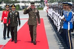 U.S, and Thai military leaders walk by an honor guard in Bangkok.