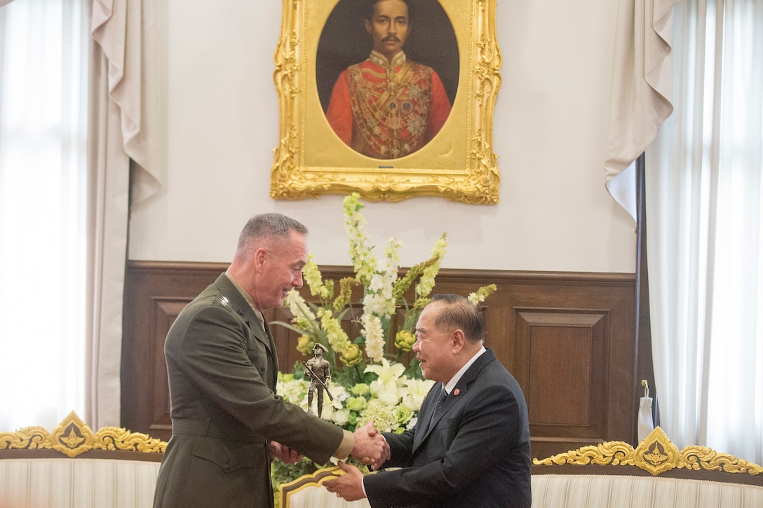 The chairman of the Joint Chiefs of Staff shakes hands with the Thai defense minister.