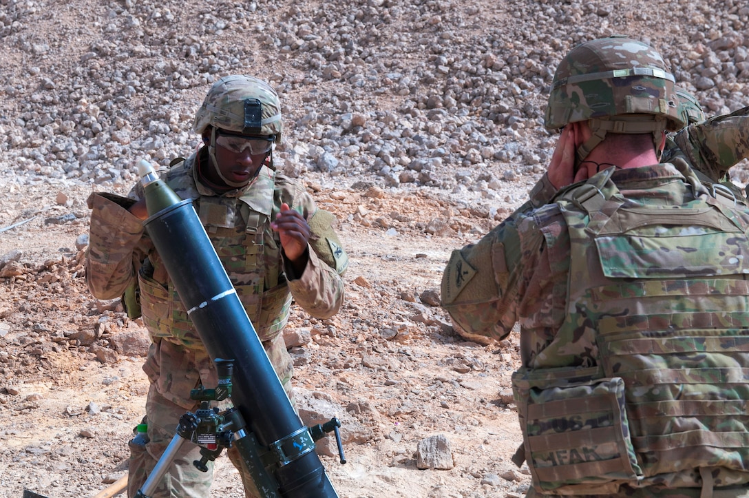 A soldier fires a 120 mm mortar system.