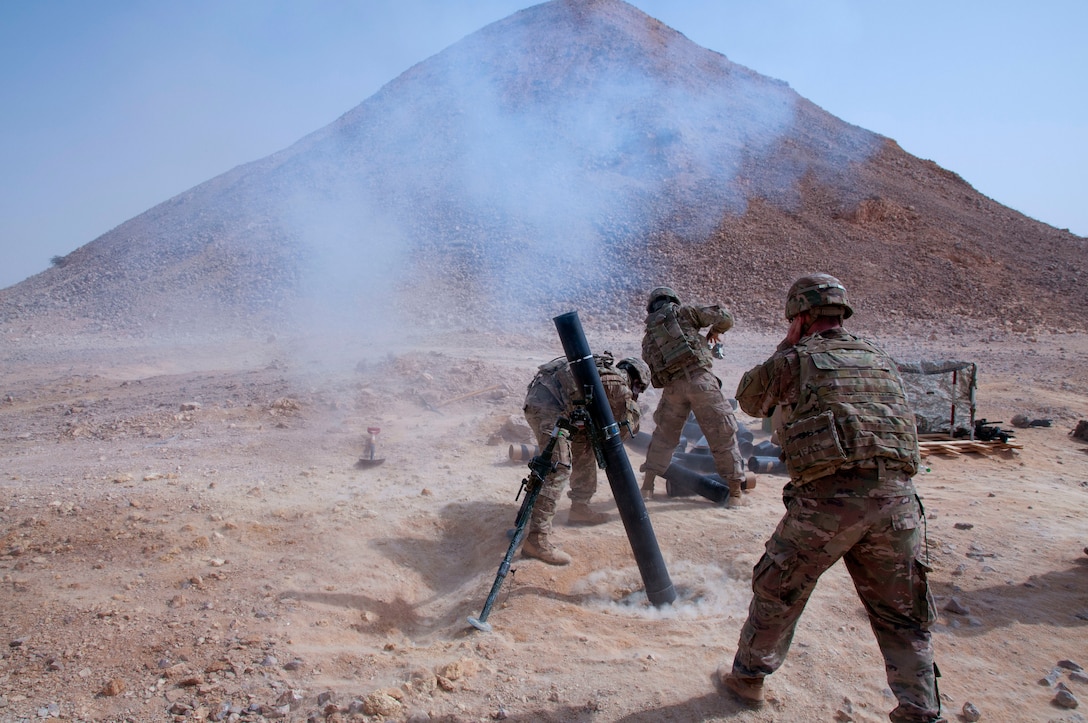 Soldiers fire a 120mm mortar system.