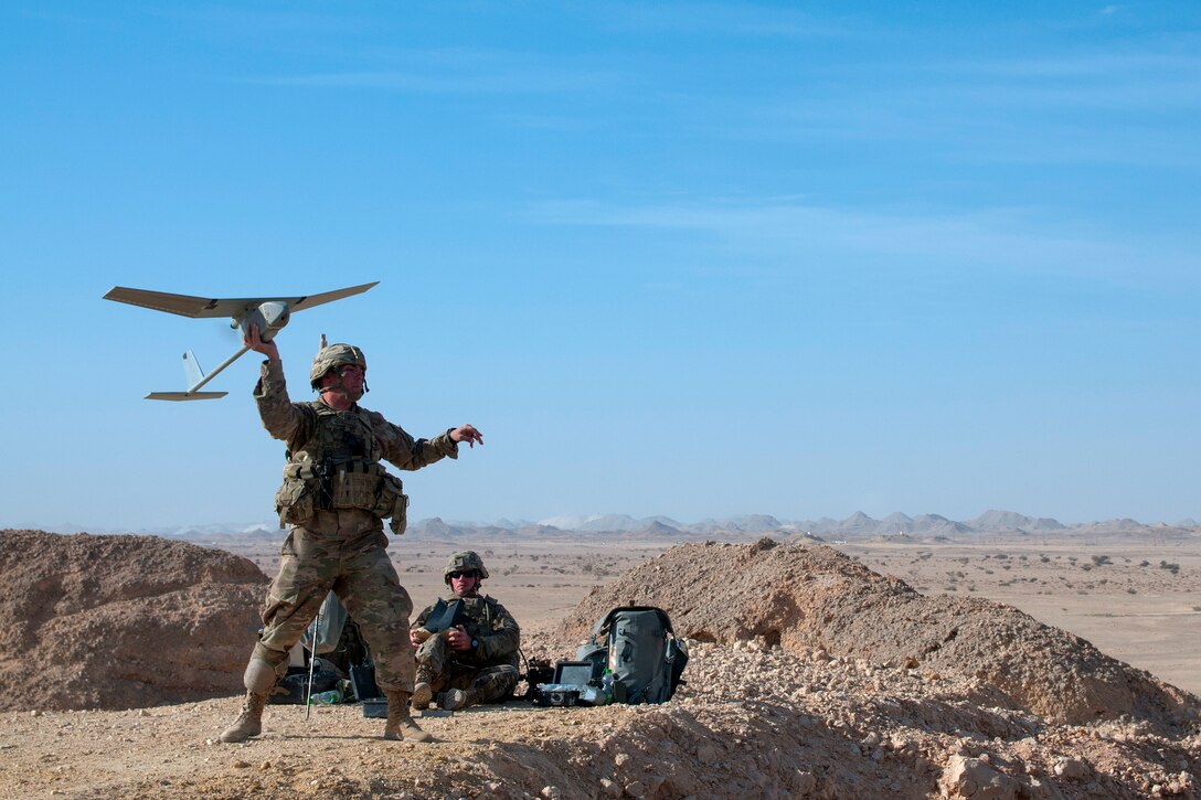 A soldier launches a Raven unmanned aerial vehicle into the sky.