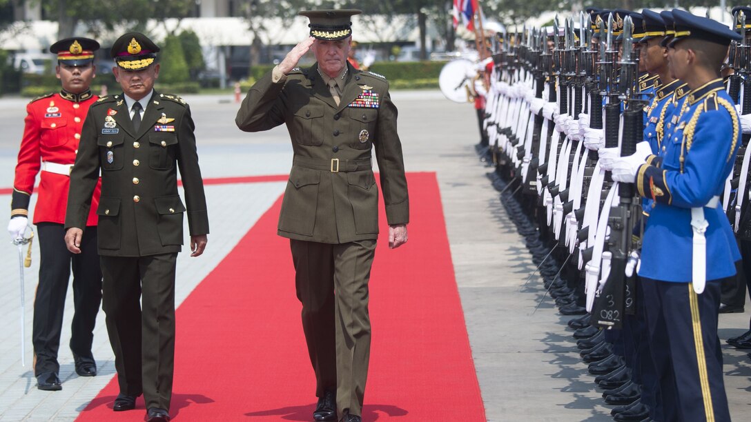 U.S, and Thai military leaders walk by an honor guard in Bangkok.