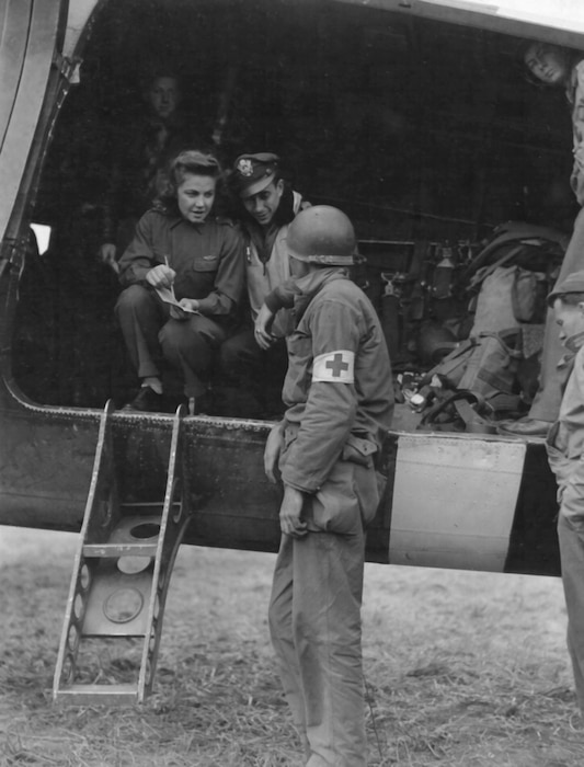 A Medical Corps Soldier gets last-minute instructions from the pilot and flight nurse before loading casualties aboard a Douglas C-47 air evacuation plane in France. (Photo courtesy of Air Force Medical Service Historian)