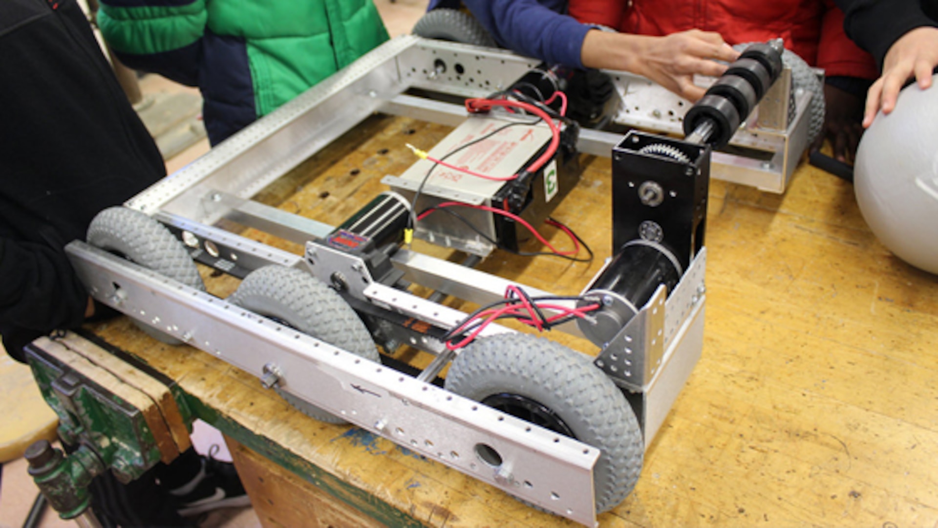 Students from Queens High School for Information, Research and Technology in Far Rockaway, N.Y. check the wiring on a robot their team built for the FIRST, For Inspiration and Recognition of Science and Technology, Robotics Competition in 2016. Defense Contract Management Agency Quality Assurance Specialist Kyle Carter volunteers as a mentor at the high school. (Courtesy photo)