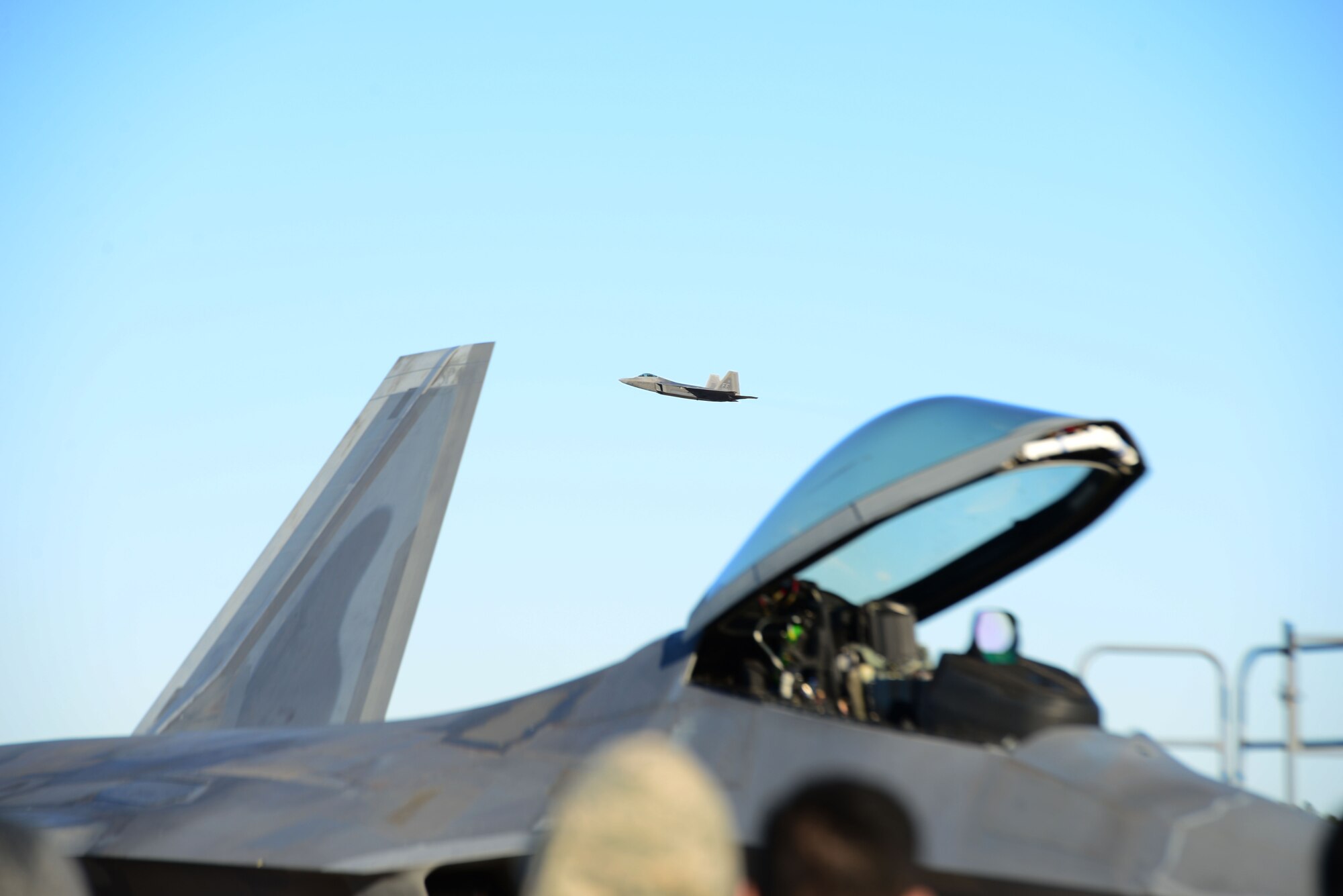 An F-22 Raptor, flown by Maj. Paul Lopez, flies by Airmen during an aerial demonstration Feb. 2, 2018, at Columbus Air Force Base, Mississippi. Lopez performed aerial demonstration at Columbus AFB in preparation for the 2018 air show season. (U.S. Air Force photo by Airman 1st Class Beaux Hebert)