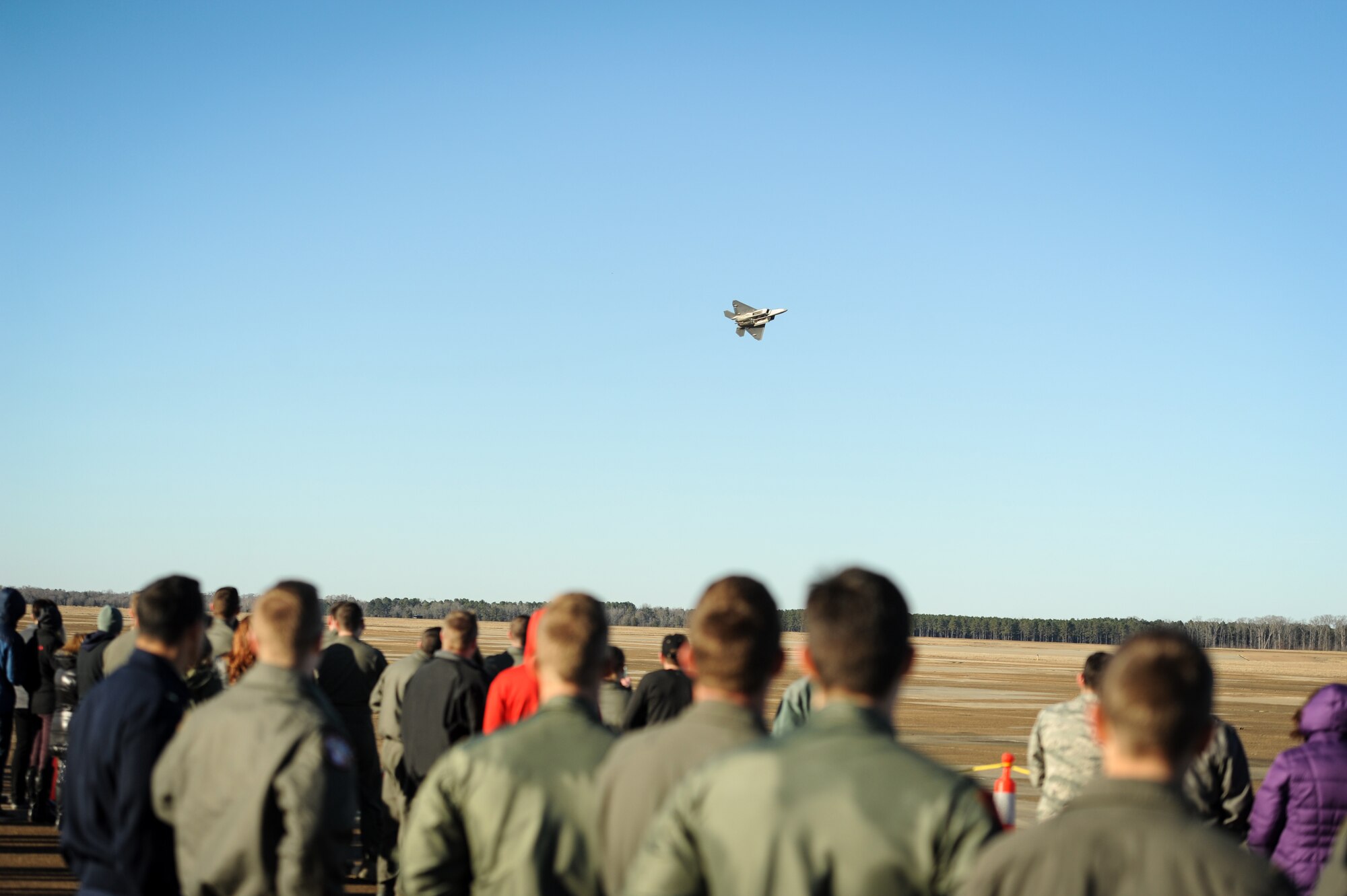 Airmen watch as an F-22 Raptor, flown by Maj. Paul Lopez, flies by during an aerial demonstration Feb. 2, 2018, at Columbus Air Force Base, Mississippi. Lopez is a member of Air Combat Command’s F-22 Single Ship Demonstration Team at Joint Base Langley Eustis, Virginia. (U.S. Air Force photo by Tech. Sgt. Christopher Gross)