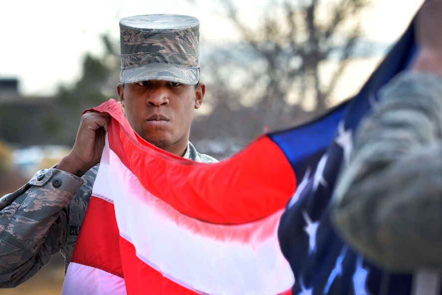 SCHRIEVER AIR FORCE BASE, Colo. -- Staff Sergeant Matthew Coleman-Foster50th Space Wing Public Affairs office prepares the flag for folding during Schriever Air Force base's retreat ceremony at the base flag pole 31 Jan, 2018 to honor the flag.  Members of the wing staff agencies made up the formation.  (U.S. Air Force Photo by Dennis Rogers