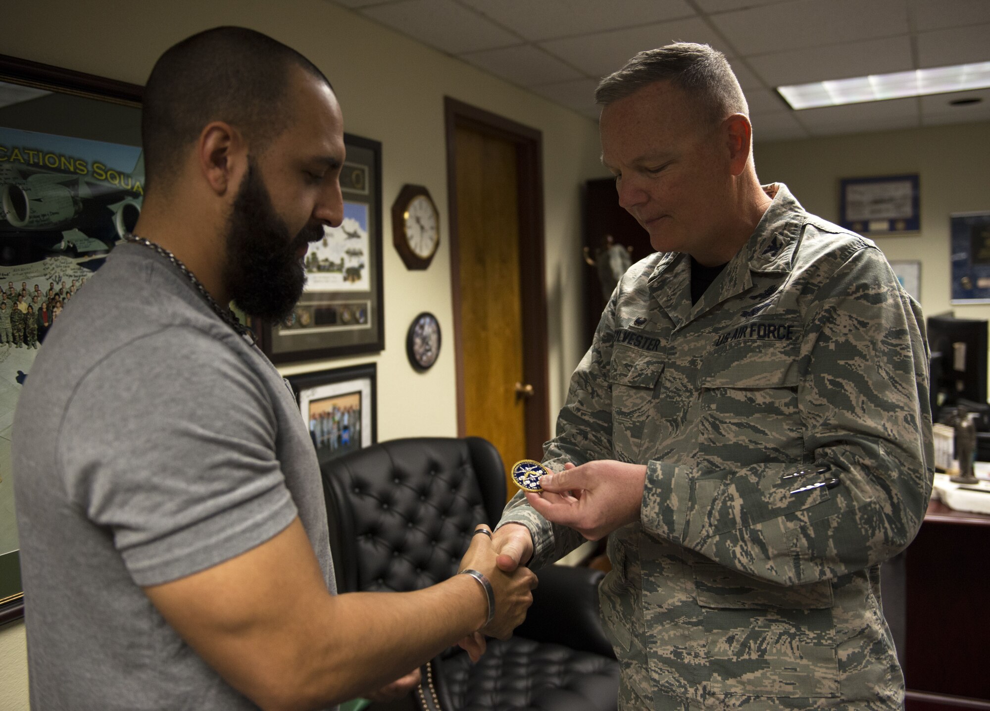 Mitchell Malloy, Gold Star family member, receives a 56th Fighter Wing coin from Col. Robert Sylvester, 56th Mission Support Group commander, at Luke Air Force Base, Ariz., Feb. 2, 2018. Malloy received a Defense Biometric Identification System Card that allows him access to all military installations. (U.S. Air Force Photo/Airman 1st Class Alexander Cook)