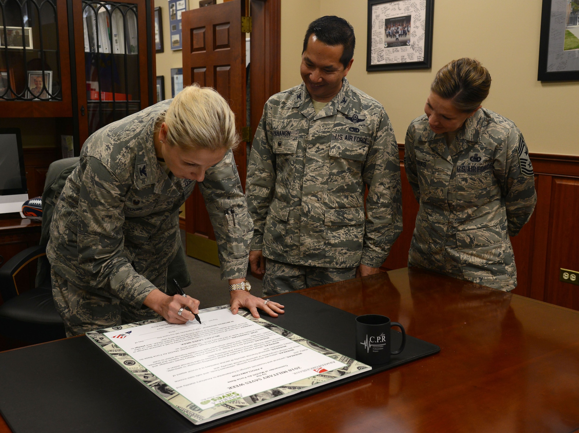 U.S. Air Force Col. April Vogel, commander of the 6th Air Mobility Wing, signs a proclamation for military saves week at MacDill Air Force Base, Fla., Feb. 1, 2018.