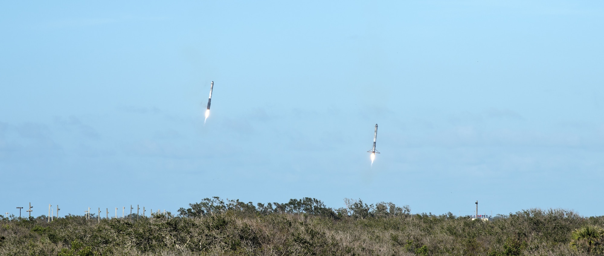 Two boosters from SpaceX's Falcon Heavy rocket approach Landing Zones 1 and 2, located at Cape Canaveral Air Force Station, Fla. on Feb. 6, 2018. The rocket, which lifted off from the historic launchpad 39A at NASA’s Kennedy Space Center, is now the most powerful launch vehicle in operation anywhere in the world. (U.S. Air Force photo by Airman Zoe Thacker)