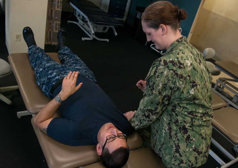 U.S. Navy Lt. Elizabeth J. Plowman, right, Naval Health Clinic Charleston head of the physical and occupational therapy department, works to improve mobility in a patient’s right shoulder Feb. 6.
