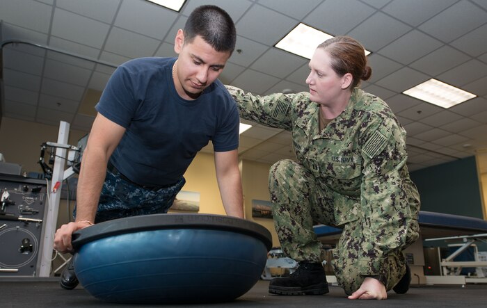 U.S. Navy Lt. Elizabeth J. Plowman, right, Naval Health Clinic Charleston head of the physical and occupational therapy department, helps a patient with exercises to improve shoulder mobility Feb. 6.