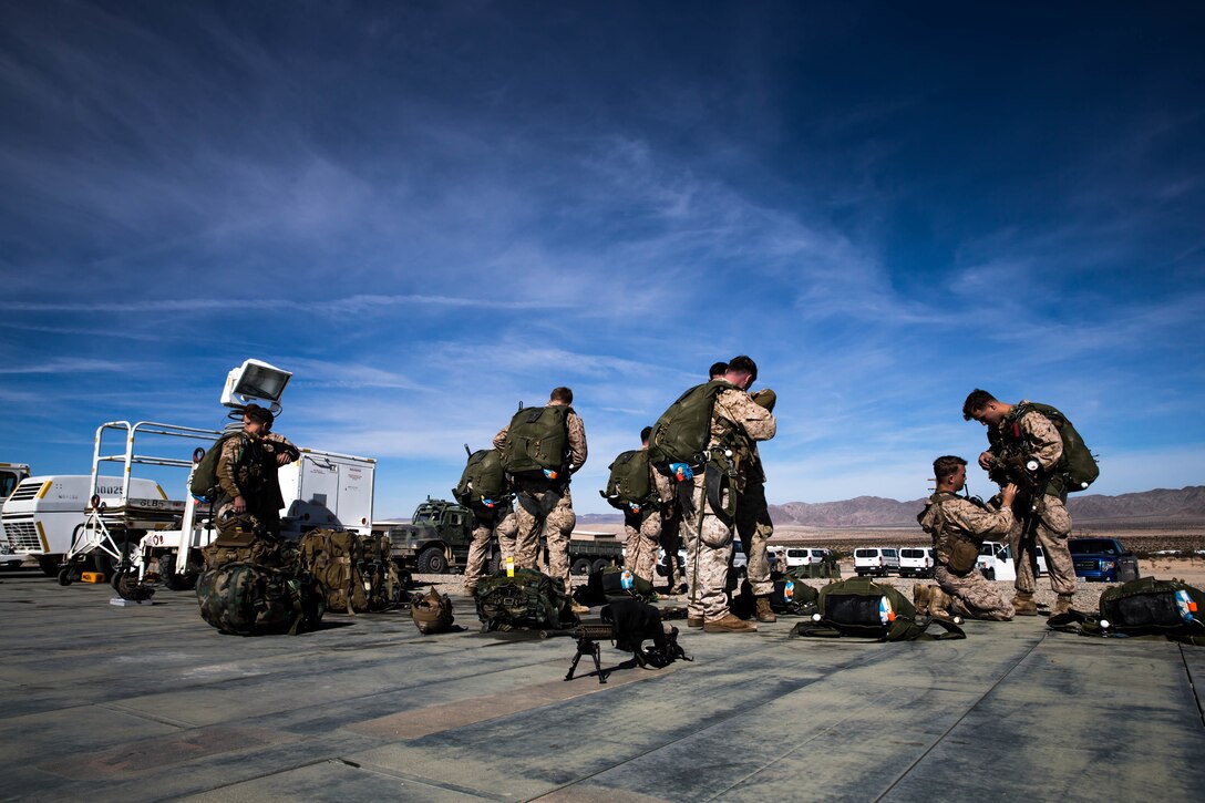 Marines with 3rd Reconnaissance Battalion, 3rd Marine Division, 3rd Marine Expeditionary Force prepare their gear at the Air Combat Element landing strip at Marine Corps Air Ground Combat Center, Twentynine Palms, Calif., Jan. 18, 2018, as a part of Integrated Training Exercise 2-18. The purpose of ITX is to create a challenging, realistic training environment that produces combat-ready forces capable of operating as an integrated MAGTF. (U.S. Marine Corps Photo by Pfc. William Chockey)